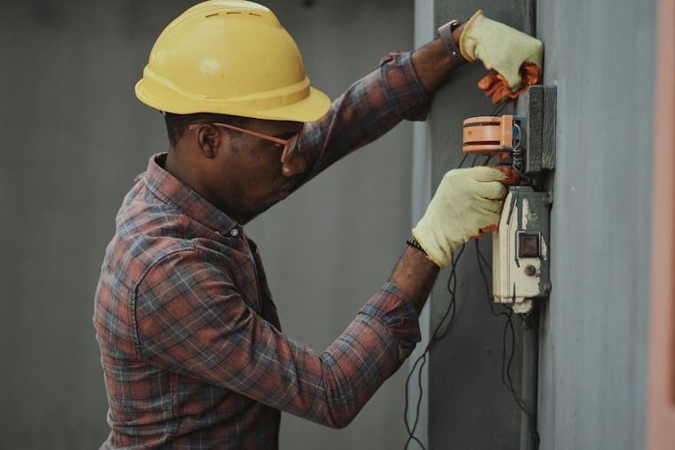 Licensed electrician working on a wall-mounted unit